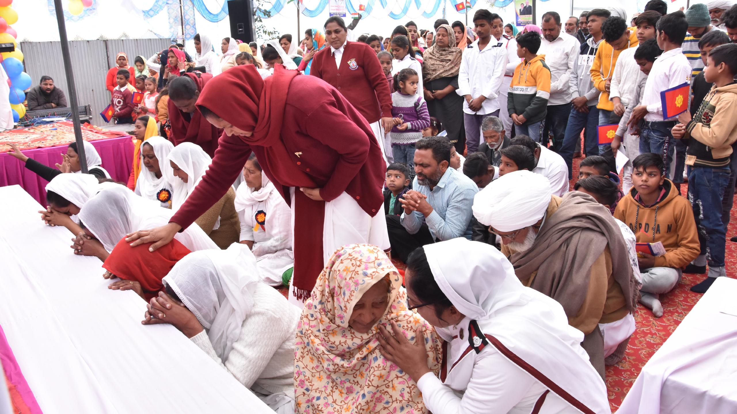 People kneel in prayer at the mercy seat