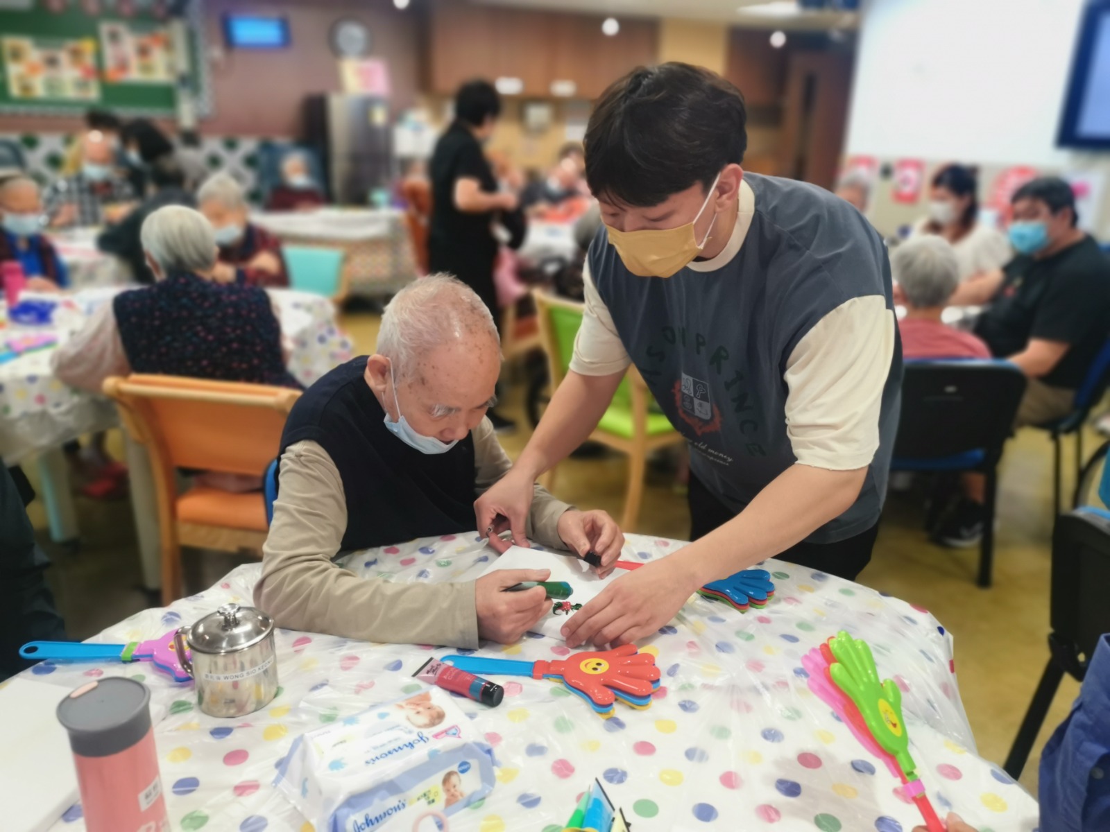 A carer assists a male resident in a care facility in Macau