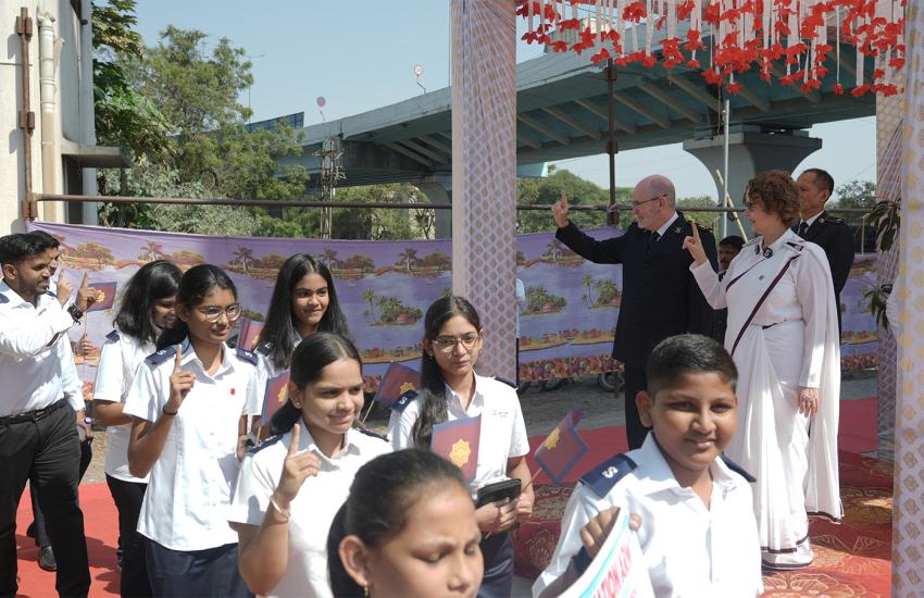 Young people in India salute as they march past the international leaders