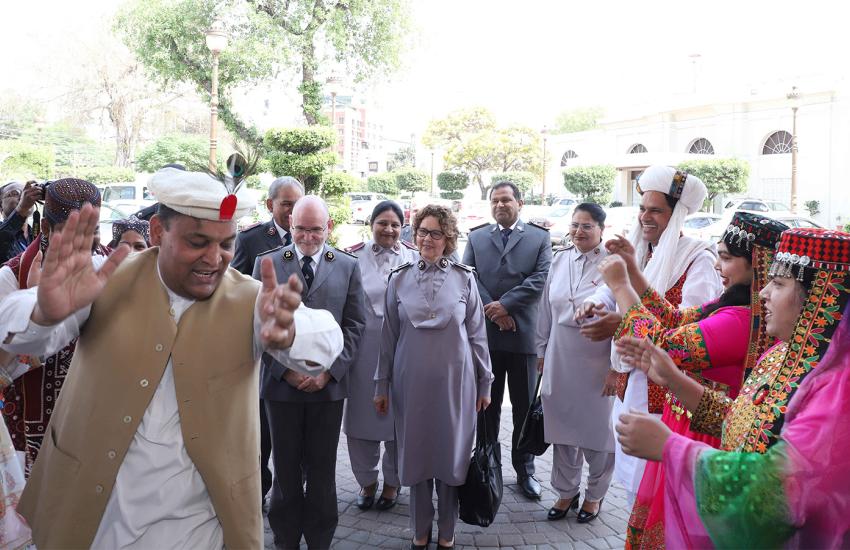 People in traditional dress dance as the international leaders are welcomed to Pakistan