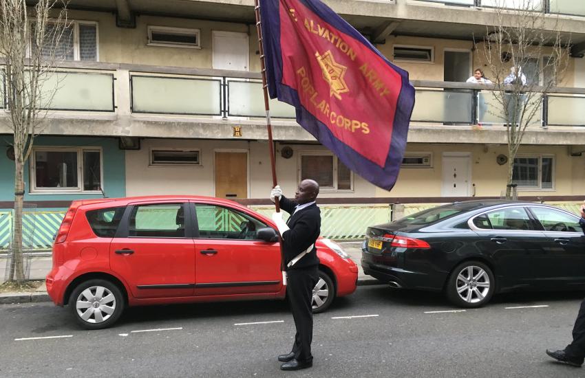 A Salvation Army soldier holds a corps flag aloft