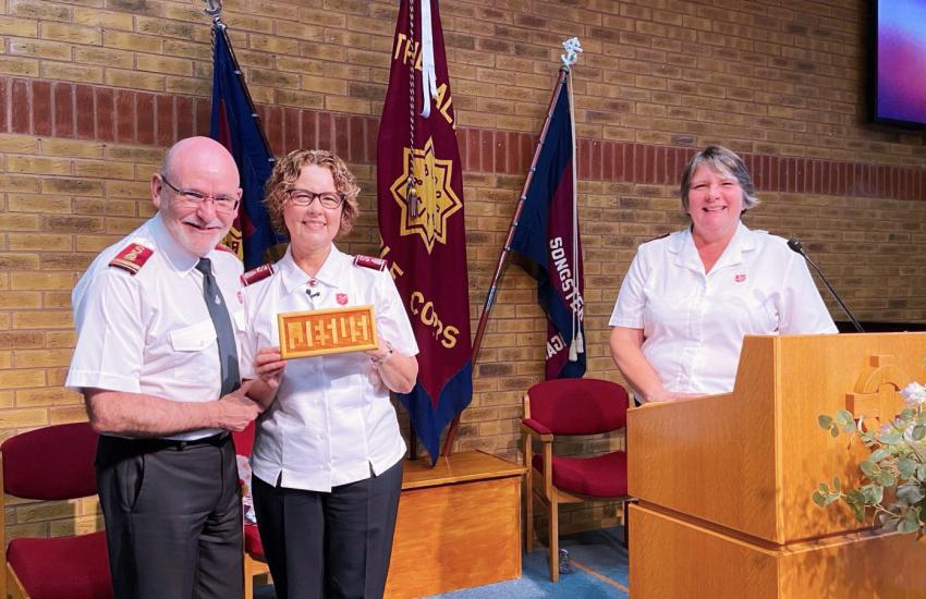General Lyndon and Commissioner Bronwyn, pictured with corps officer Captain Jacqueline Coates, are gifted a 'Jesus board' during their visit to Dunstable